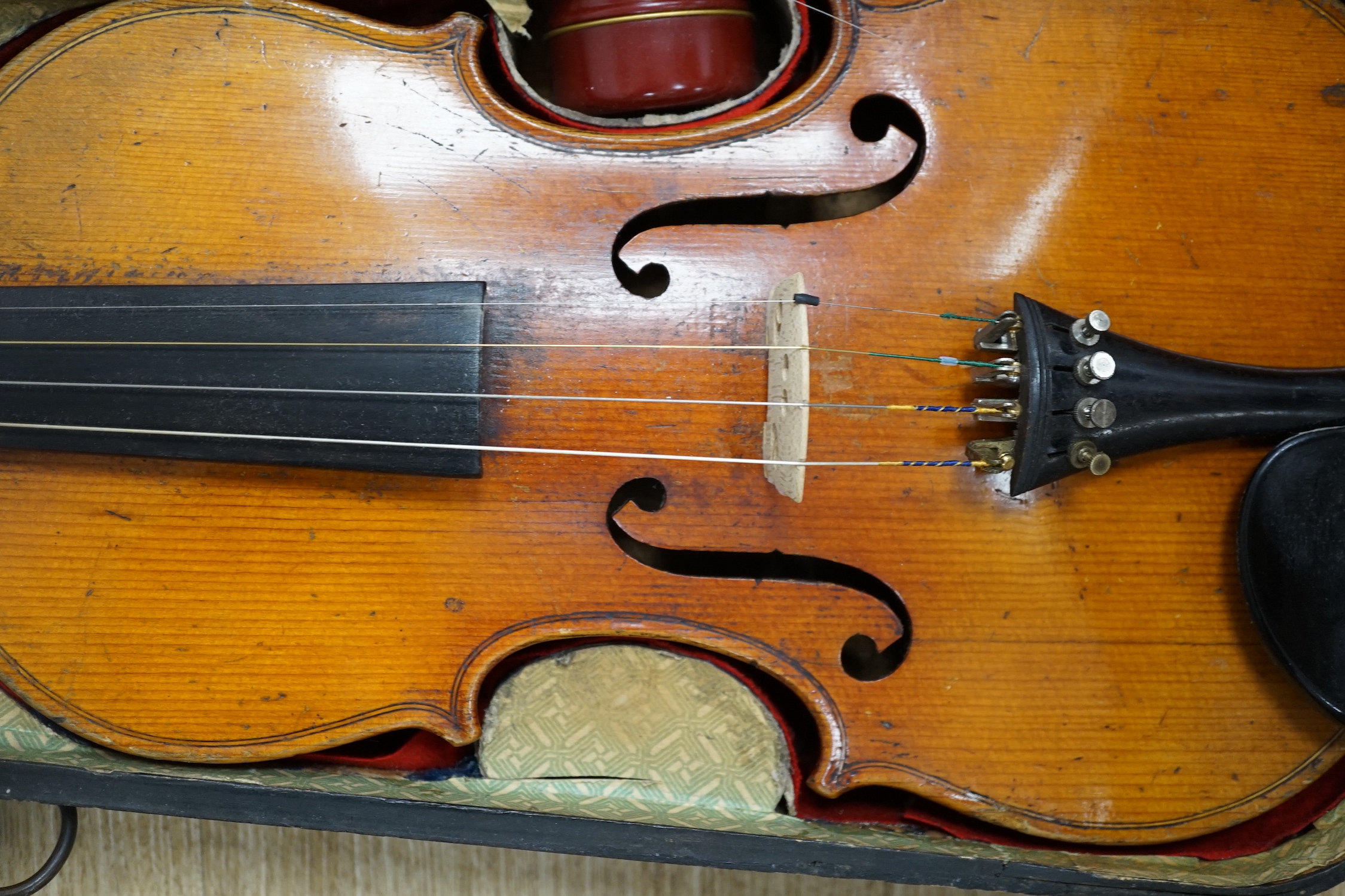 A mid 19th century cased French violin, length of body 35.5cm, with bow, simulated ivory tip